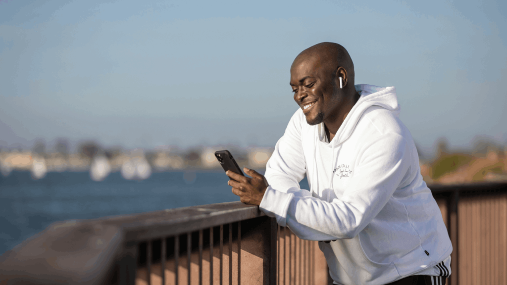 Black man looking at his phone and smiling