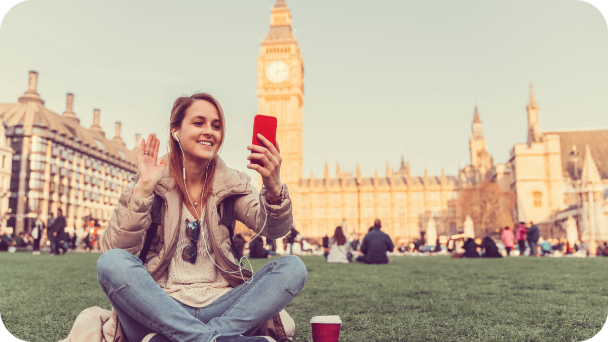 women smiling and waving her hand looking at her phone