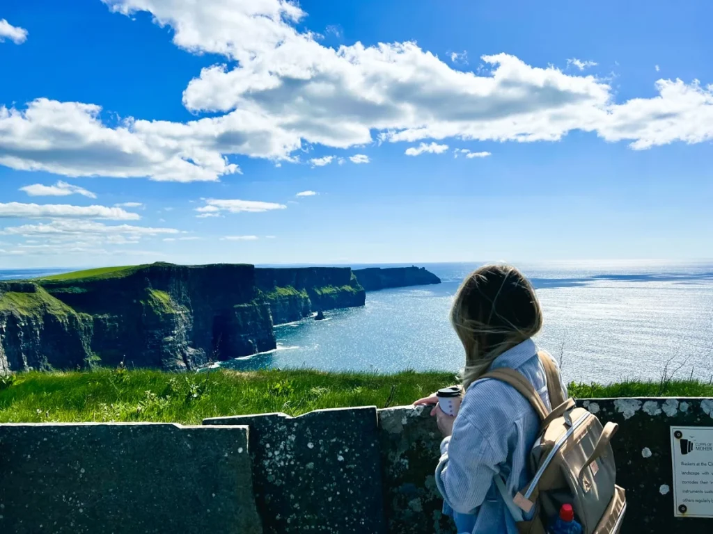 Girl looking over cliffs of Moher, Ireland