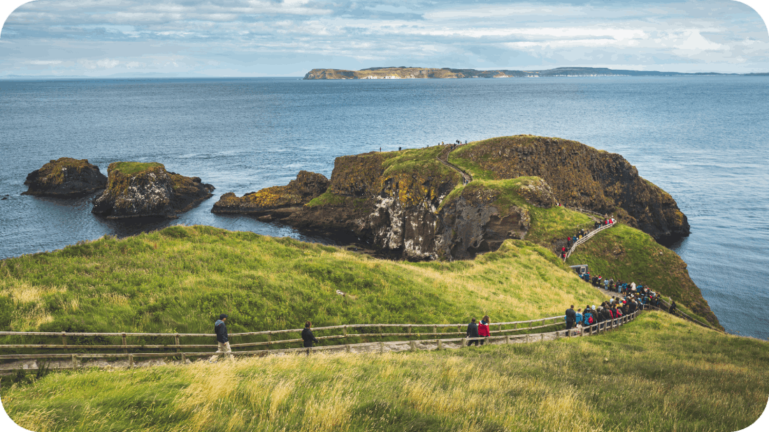 Tourists on the wooden path to the ocean in Northern Ireland