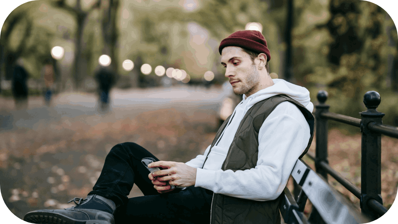 Man sitting in the park looking at his phone