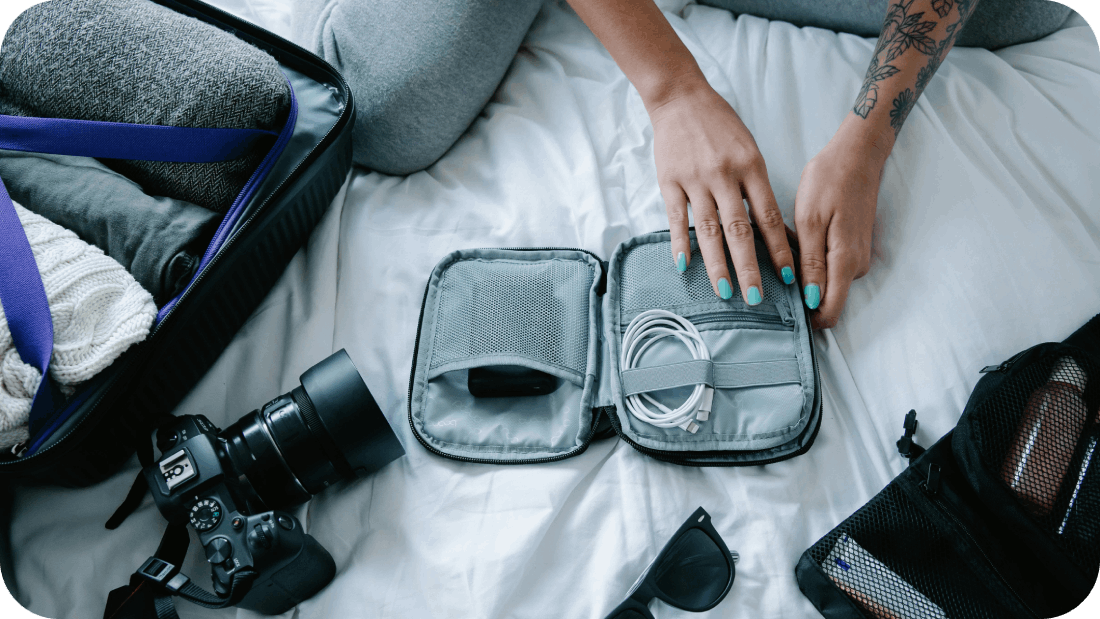 Hands on Gray Bag with Cable Charger while packing for travel