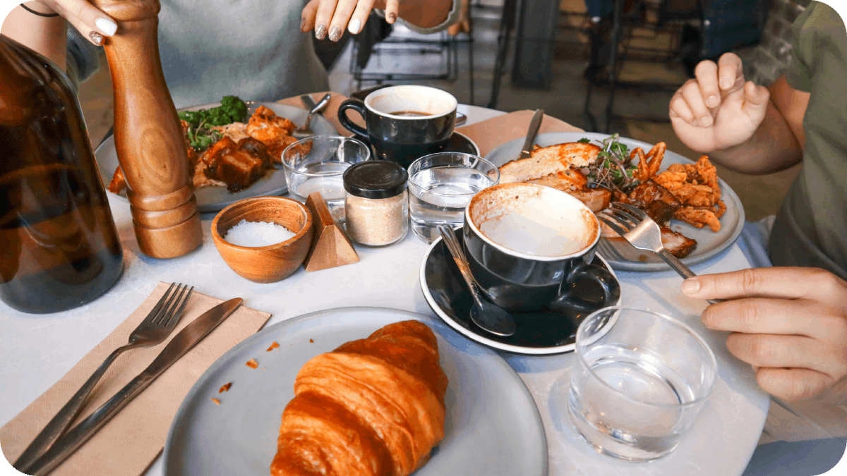 A close-up of a cozy brunch table with croissants, coffee, and savory dishes, evoking a relaxed dining atmosphere.