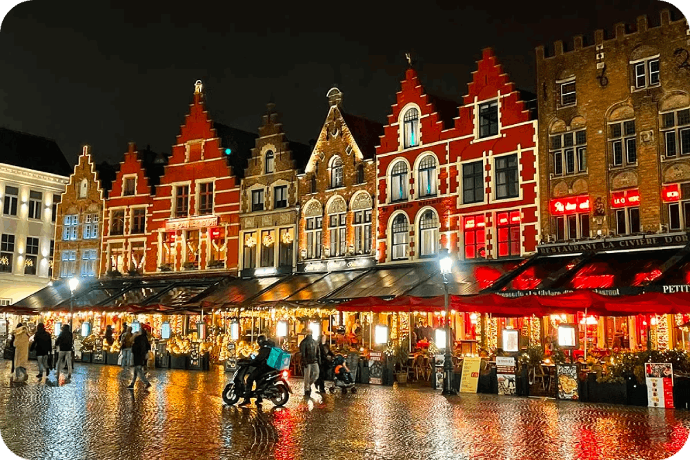 Festive Bruges illuminated at night, featuring charming medieval architecture and cozy Christmas markets.