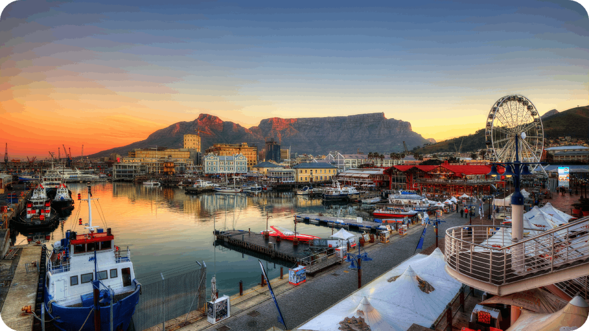 A stunning sunset view of Cape Town's V&A Waterfront with Table Mountain in the background.