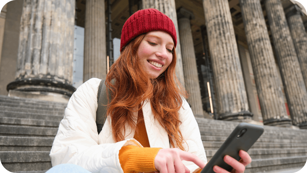 Stylish young redhead woman talking on mobile phone using Slick app 